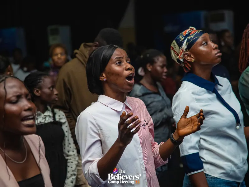 Believers standing together in worship during a session.